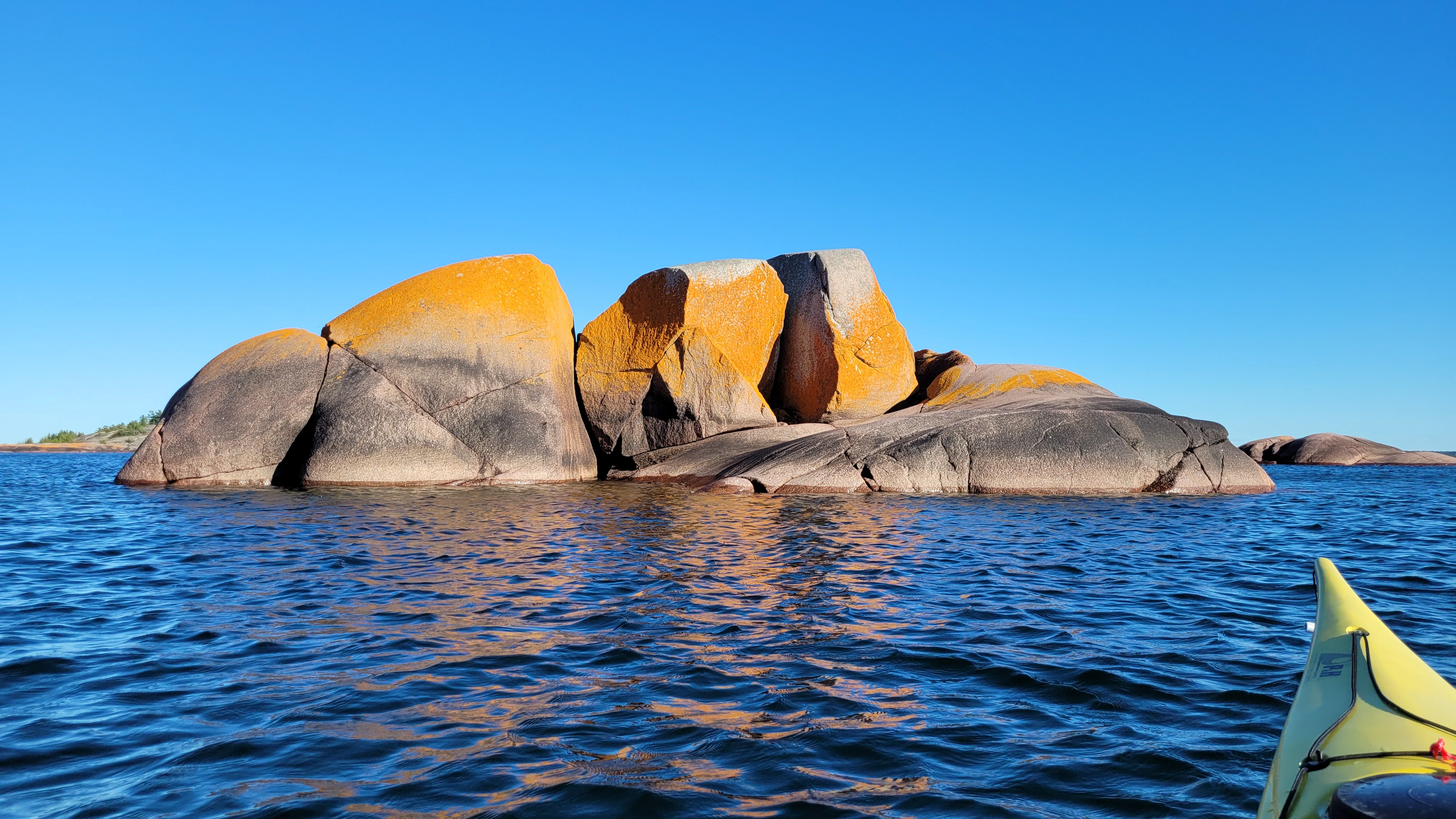 A seak rock with orange lichen near the Benjamin Islands in Northern Ontrario, Canada
