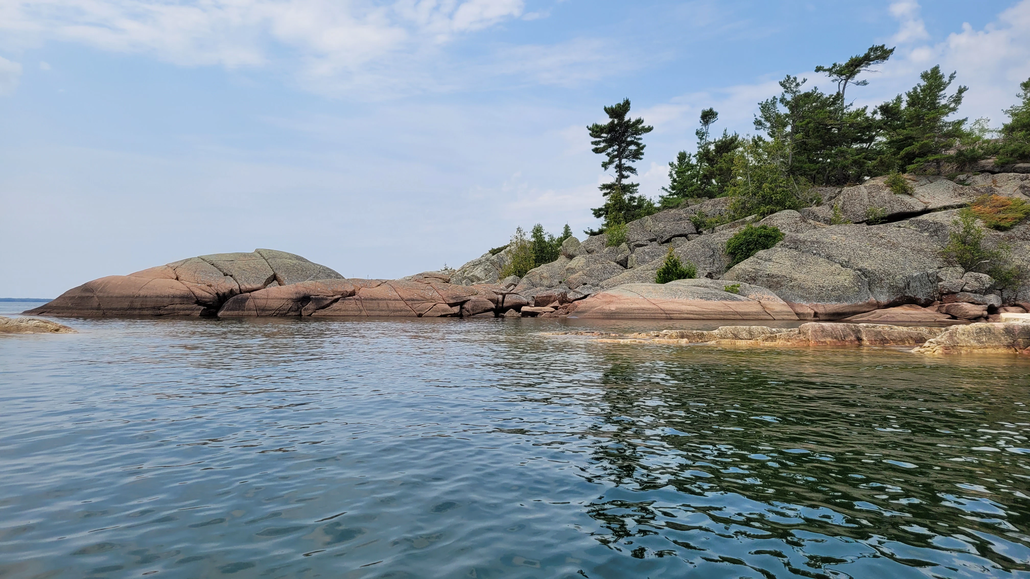 A sunset, silouhette of pine trees and two cliffs on North Benjamin Island in Northern Ontrario, Canada
