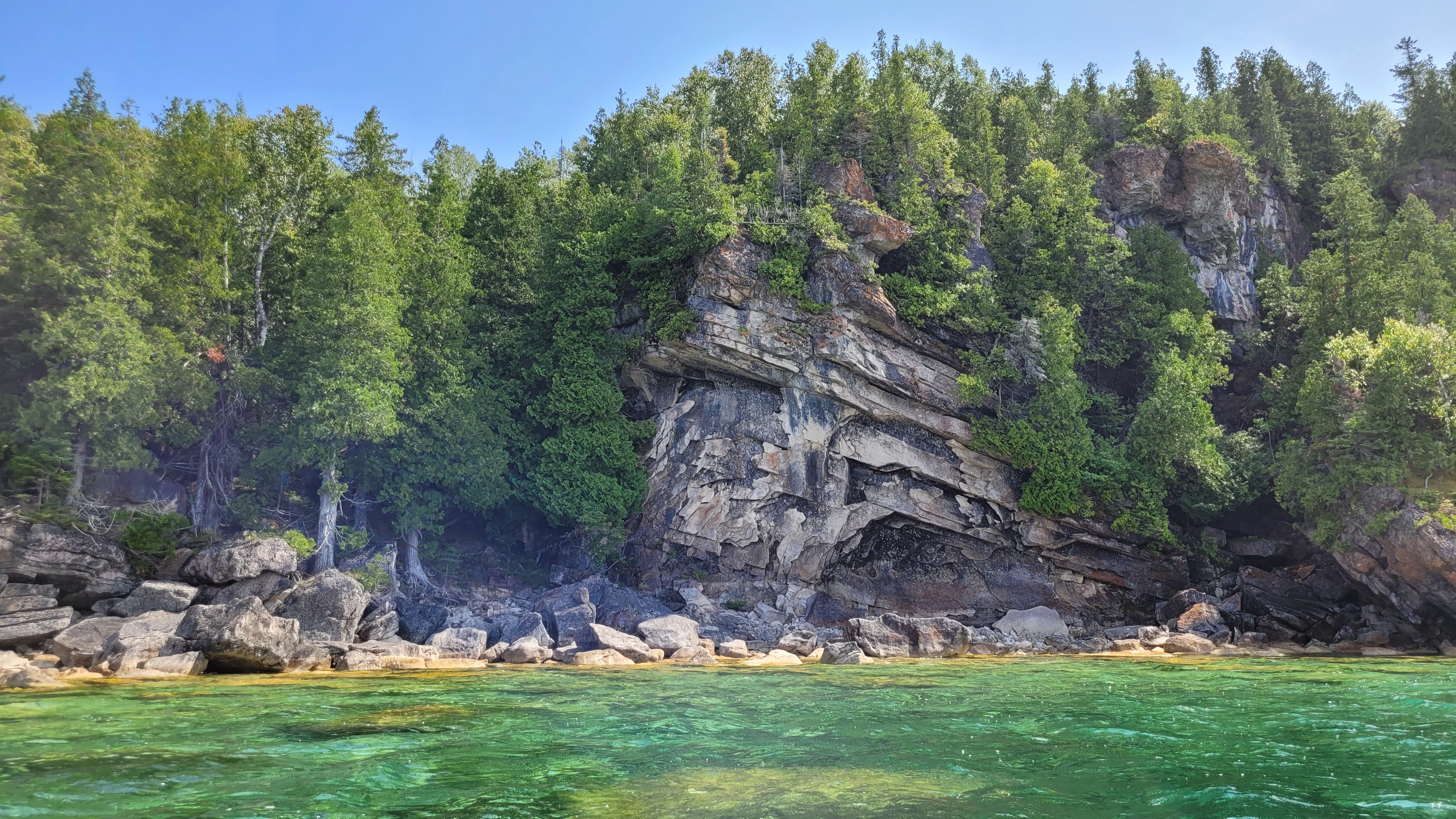 Limestone cliff topped with windswept cedar trees along the Bruce Peninsula