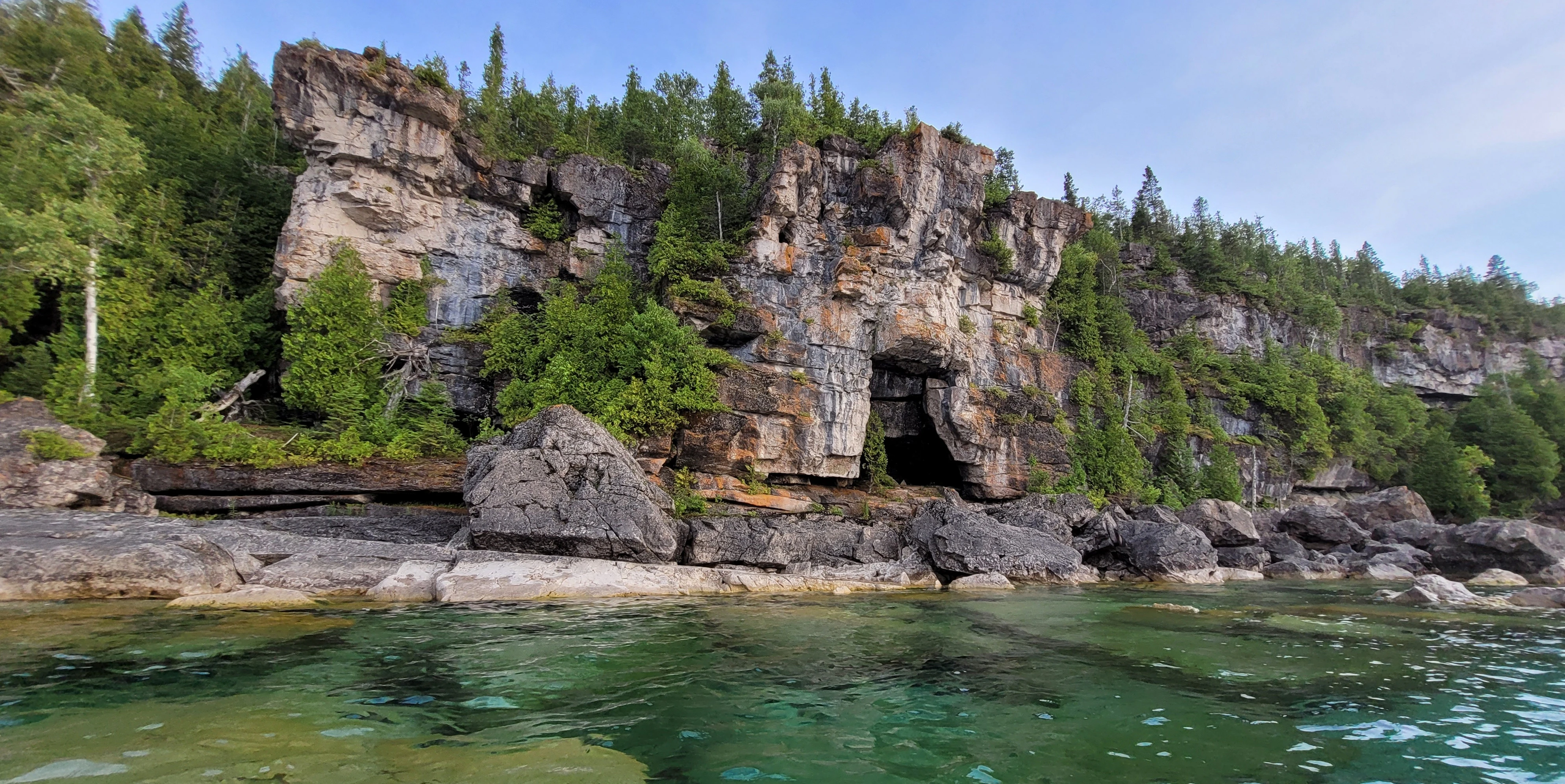 Natural arch and gate-shaped cave formation in a limestone cliff