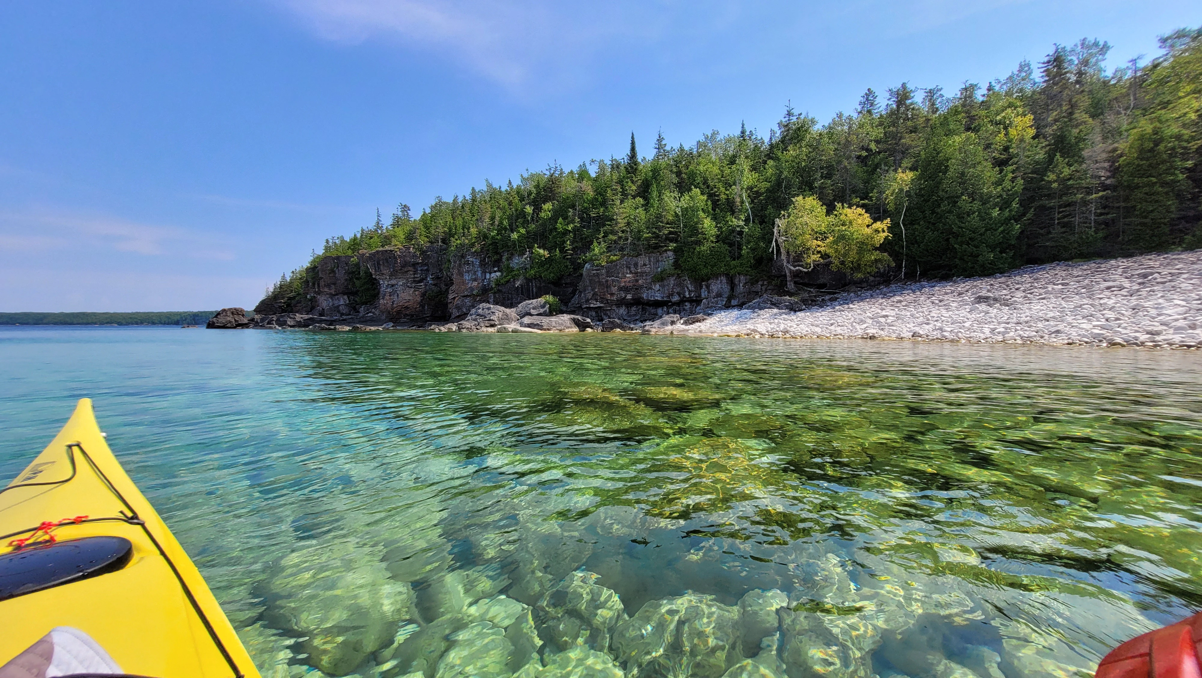 Sea kayaking over crystal clear water along the Bruce Peninsula National Park shoreline