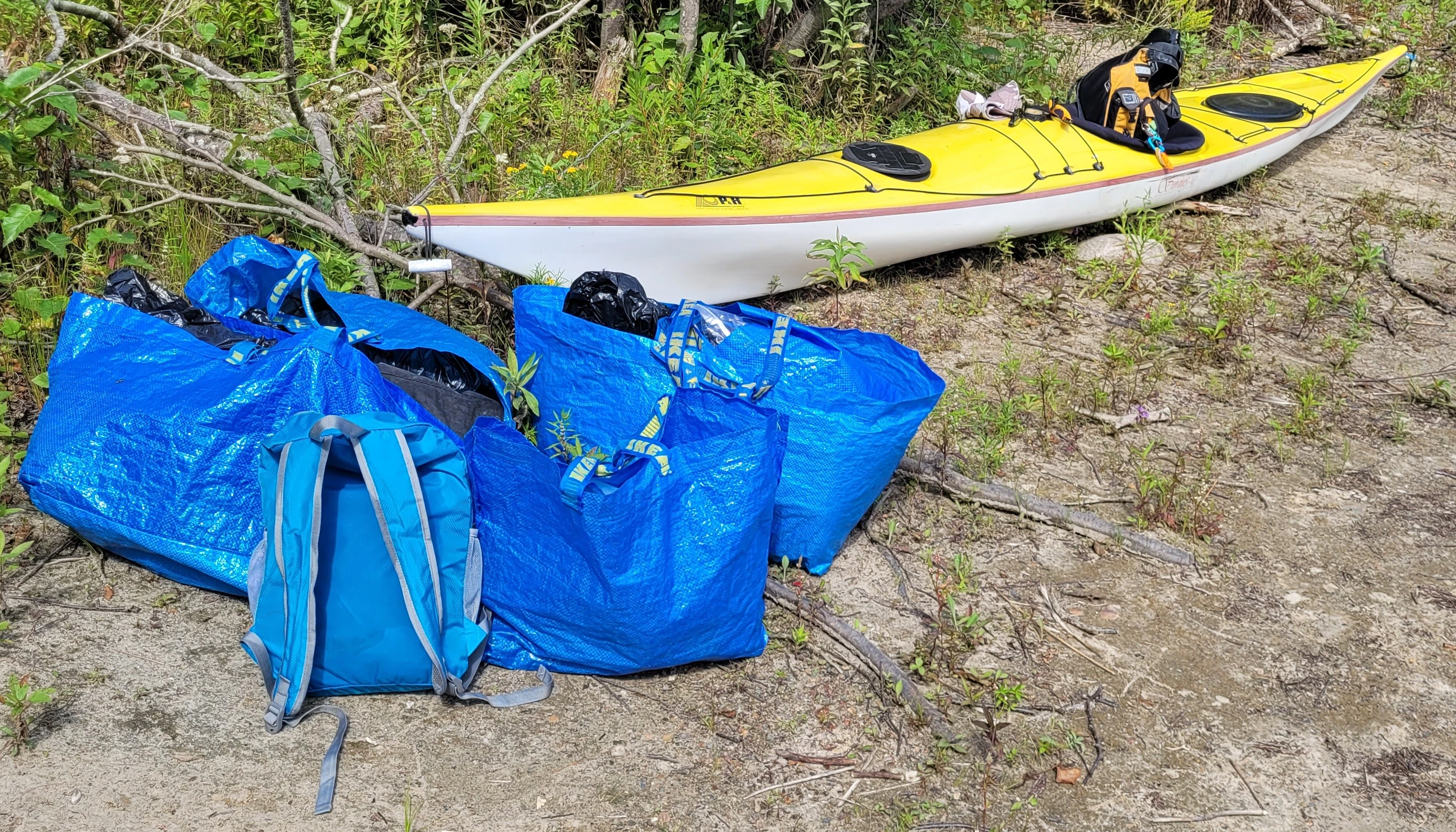Blue Ikea Bags Frakta loaded with camping gear next to a sea kayak