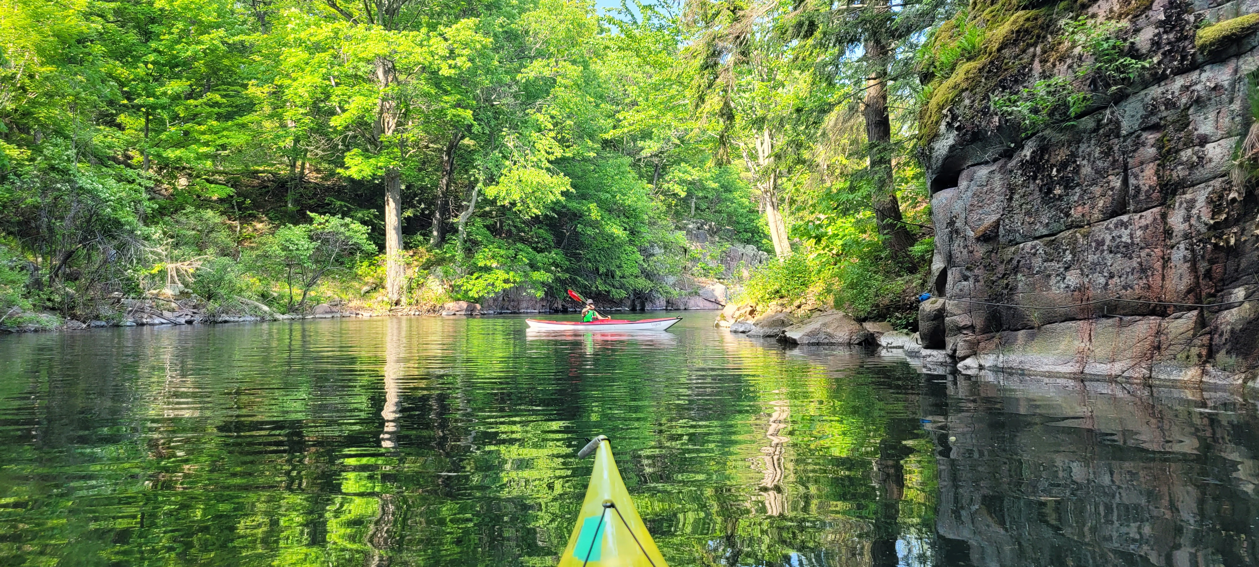 Colorful trees reflecting off the water in Half Moon Bay during a kayak trip to the Thousand Islands in Ontario, Canada