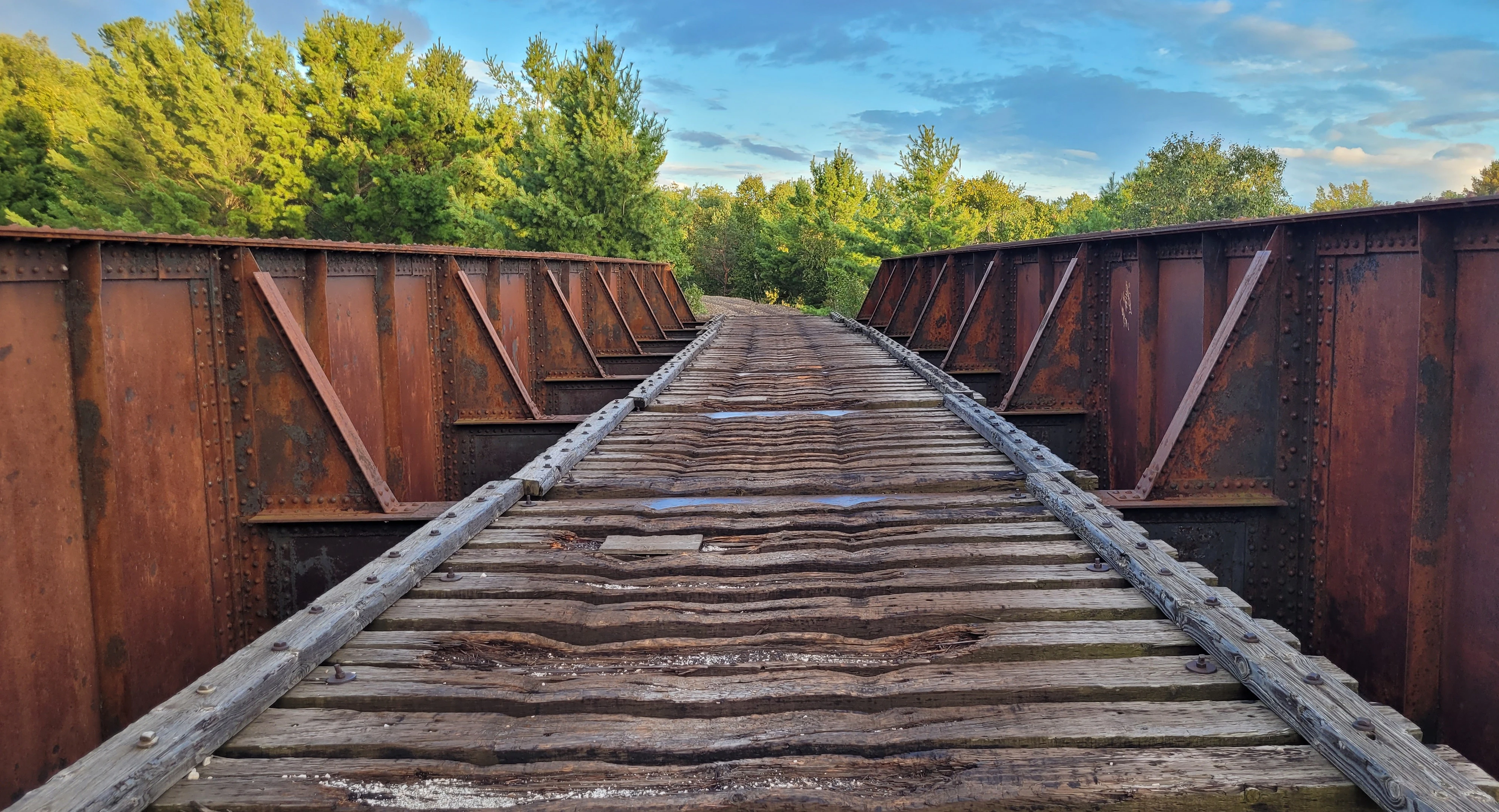A rustic, red metal bridge