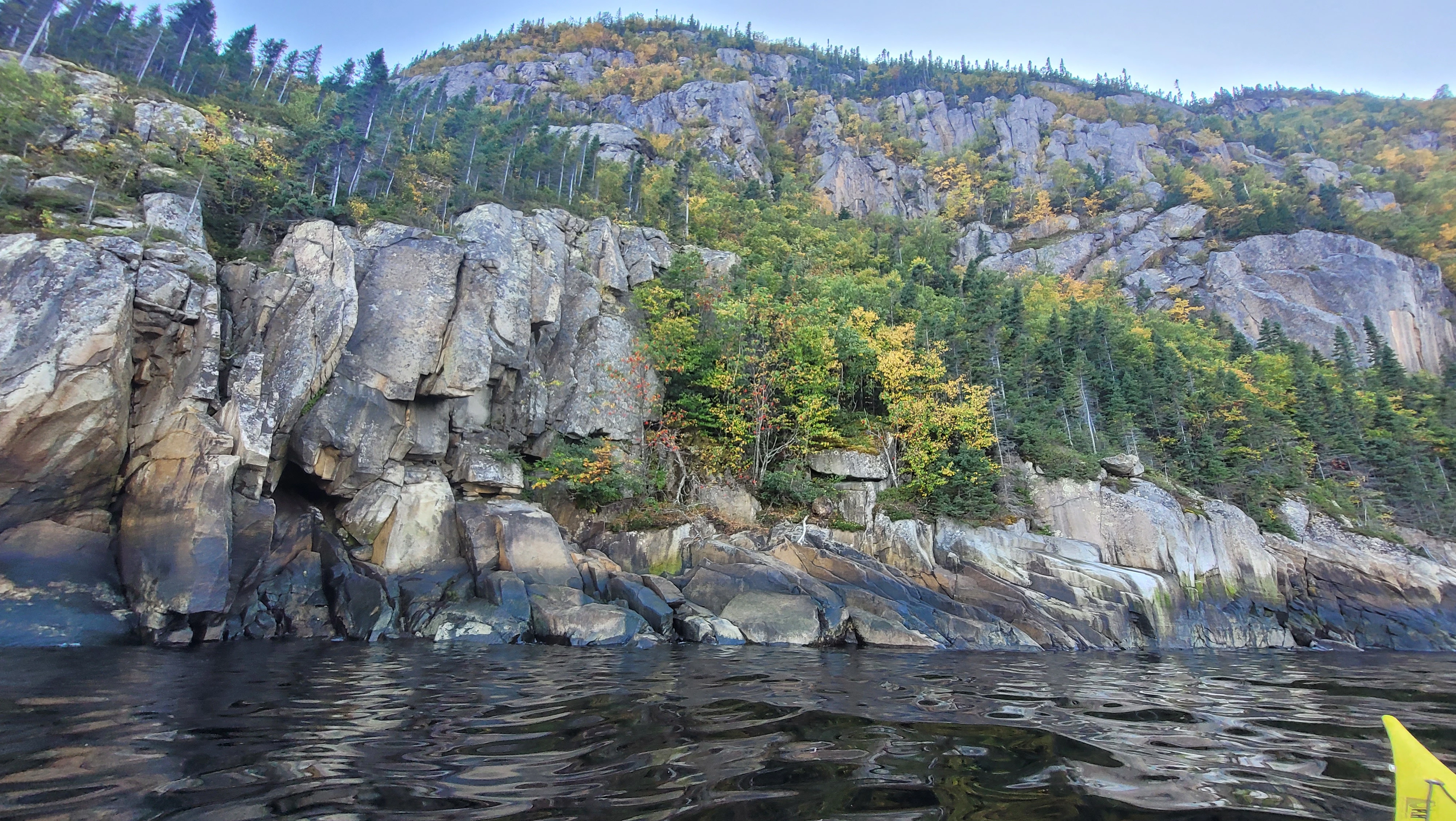Colorful cliffs with trees growing on the rocks along the fjords of the Saguenay river